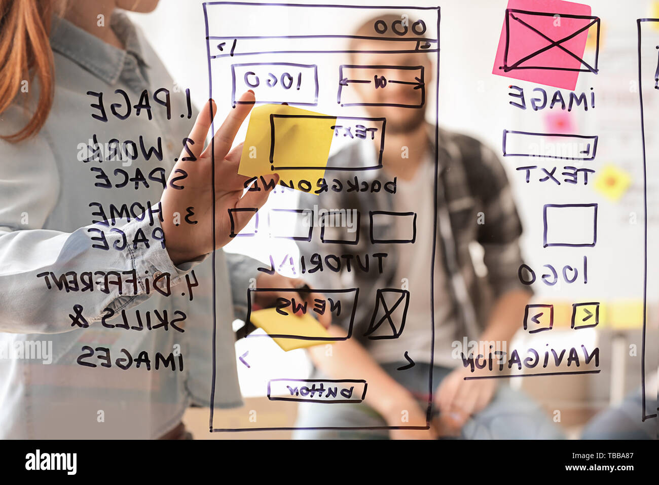 IT designers discussing project, view through transparent board Stock Photo