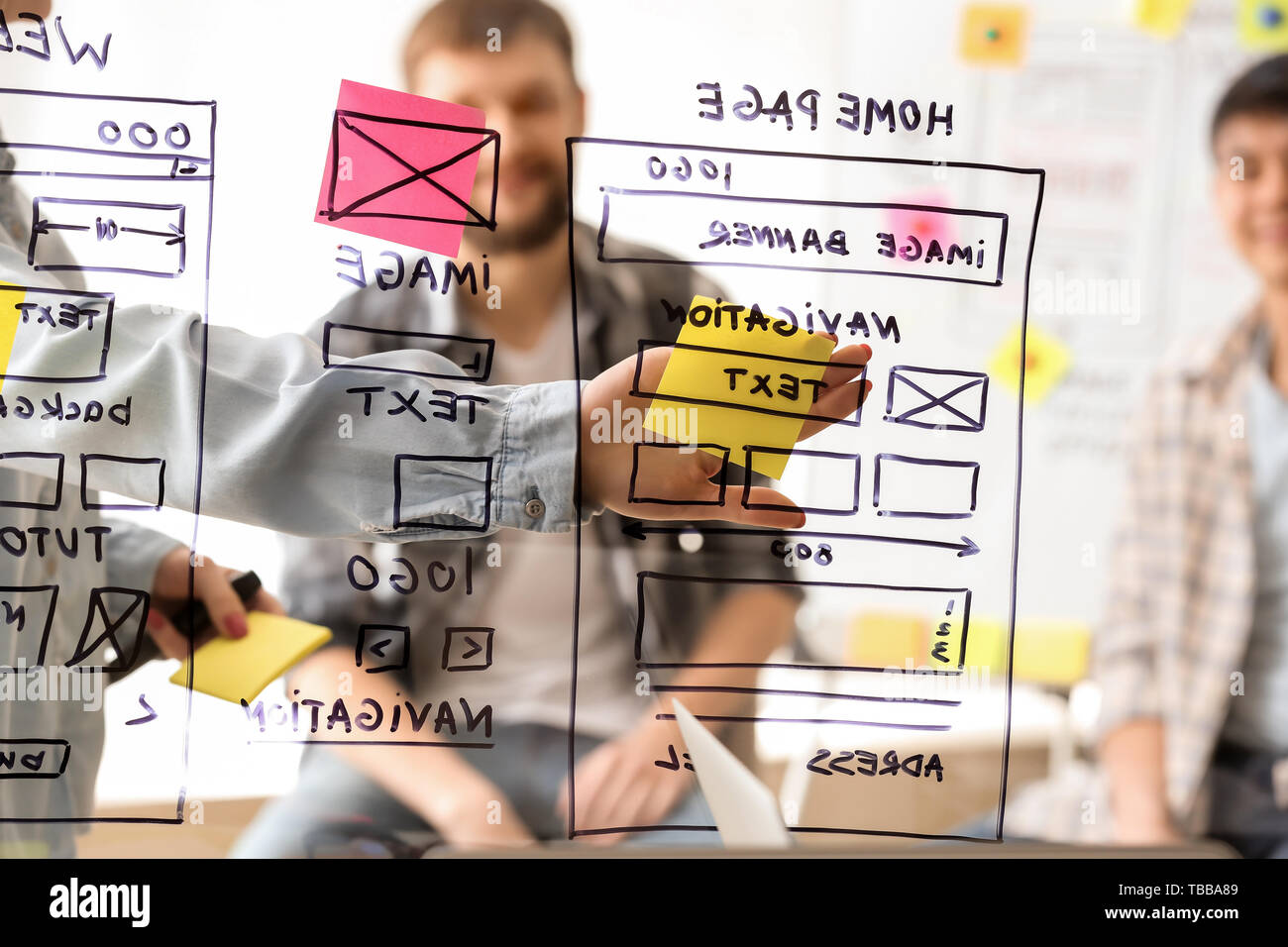 IT designers discussing project, view through transparent board Stock Photo