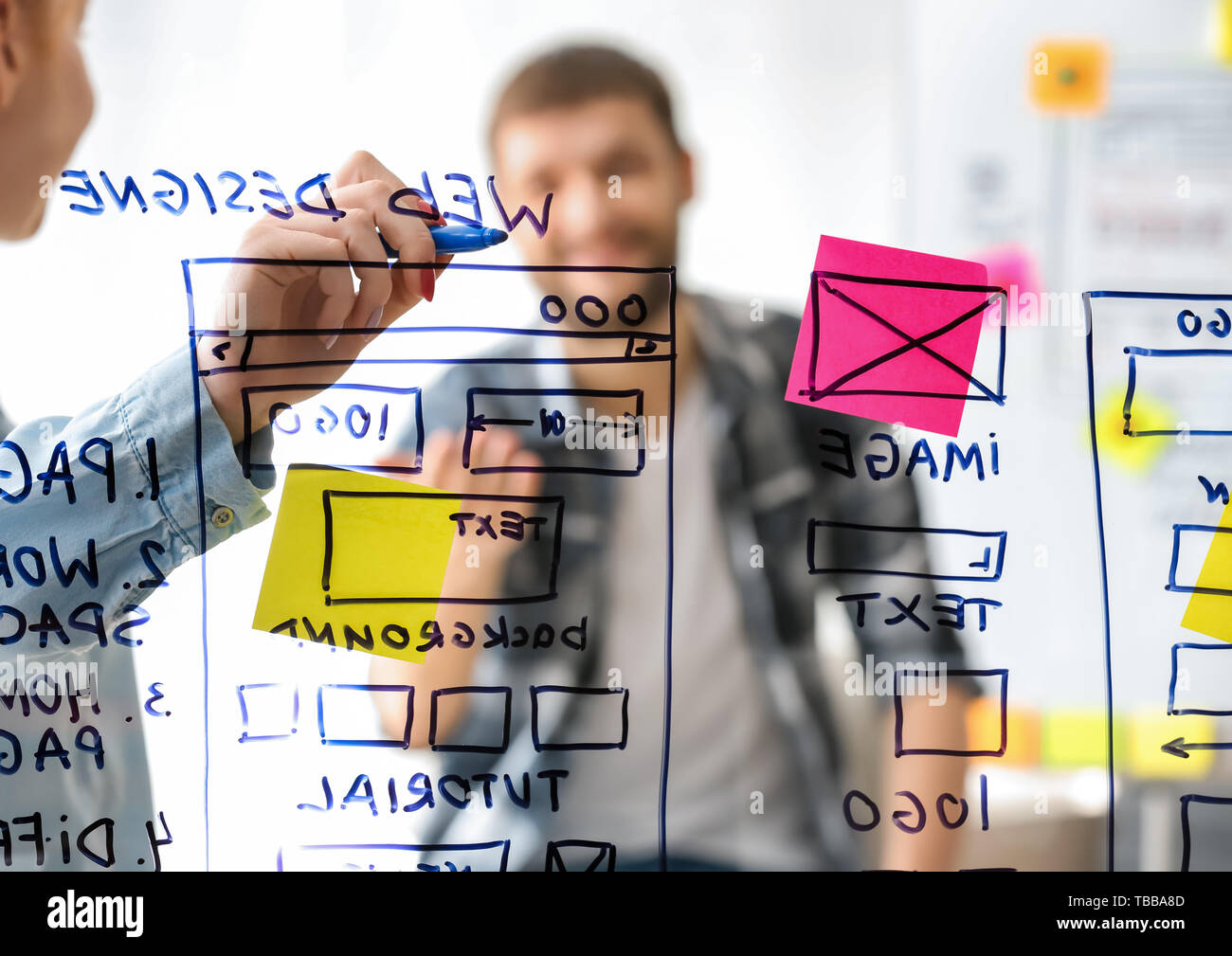 IT designers discussing project, view through transparent board Stock Photo