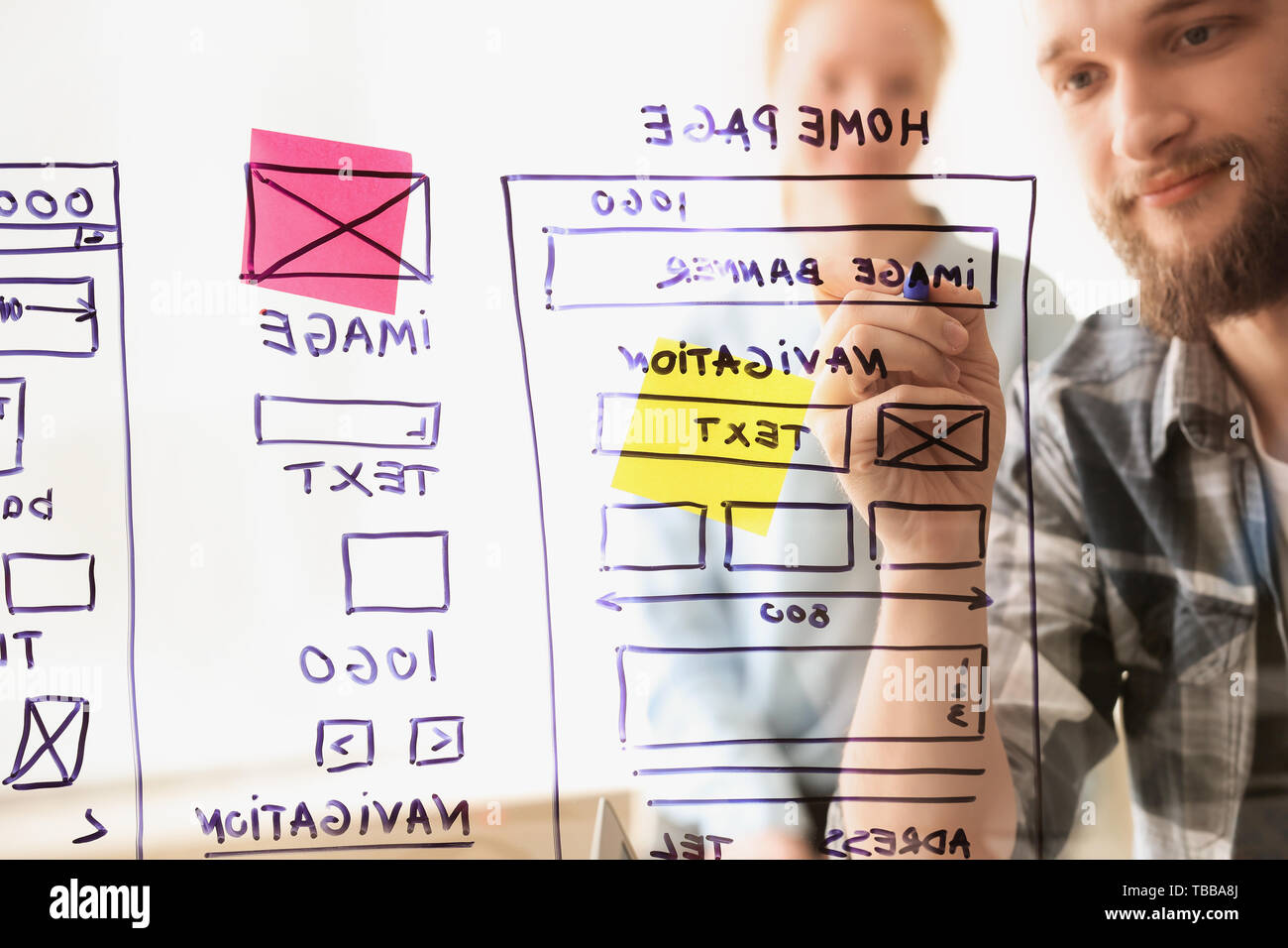 IT designers discussing project, view through transparent board Stock Photo