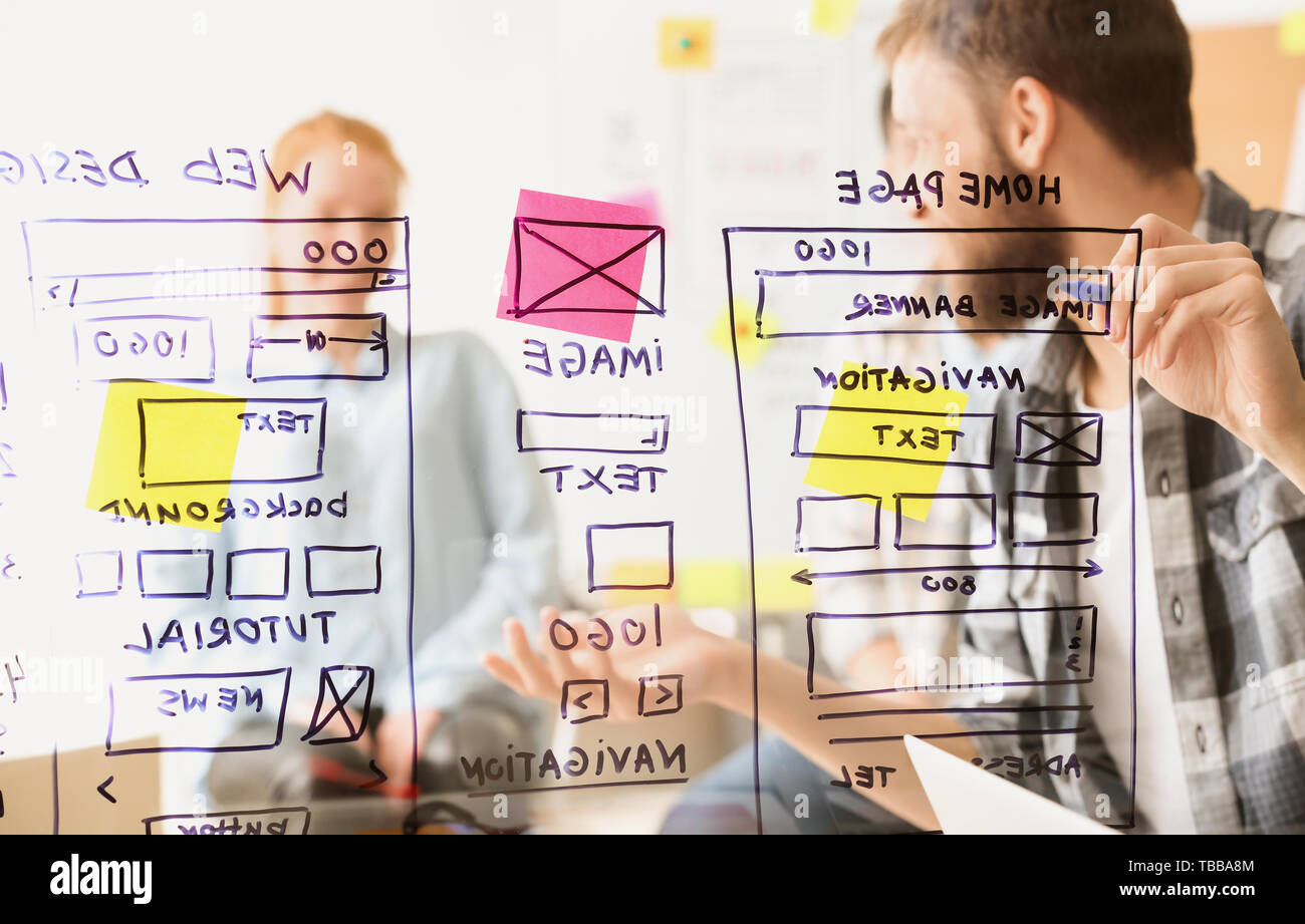 IT designers discussing project, view through transparent board Stock Photo