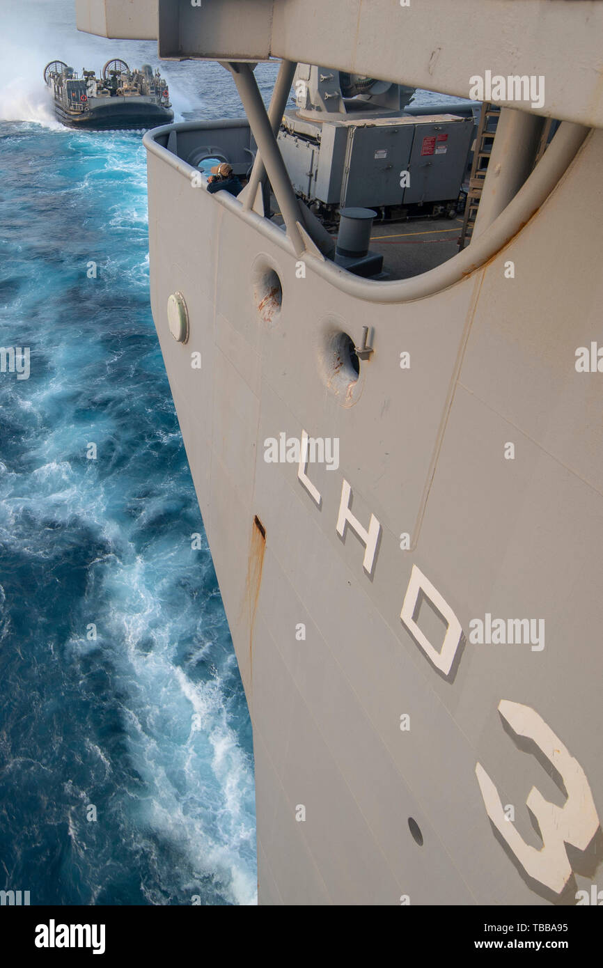 190524-N-IK871-1071 ARABIAN SEA (May 23, 2019) ) A U.S. Navy landing craft, air cushion approaches the well deck of the Wasp-class amphibious assault ship USS Kearsarge (LHD 3) during training. Kearsarge is the flagship for the Kearsarge Amphibious Ready Group (ARG). The Kearsarge ARG and the embarked 22nd Marine Expeditionary Unit (MEU) are deployed to the U.S. 5th Fleet area of operations in support of naval operations to ensure maritime stability and security in the Central Region, connecting the Mediterranean and the Pacific through the western Indian Ocean and three strategic choke points Stock Photo