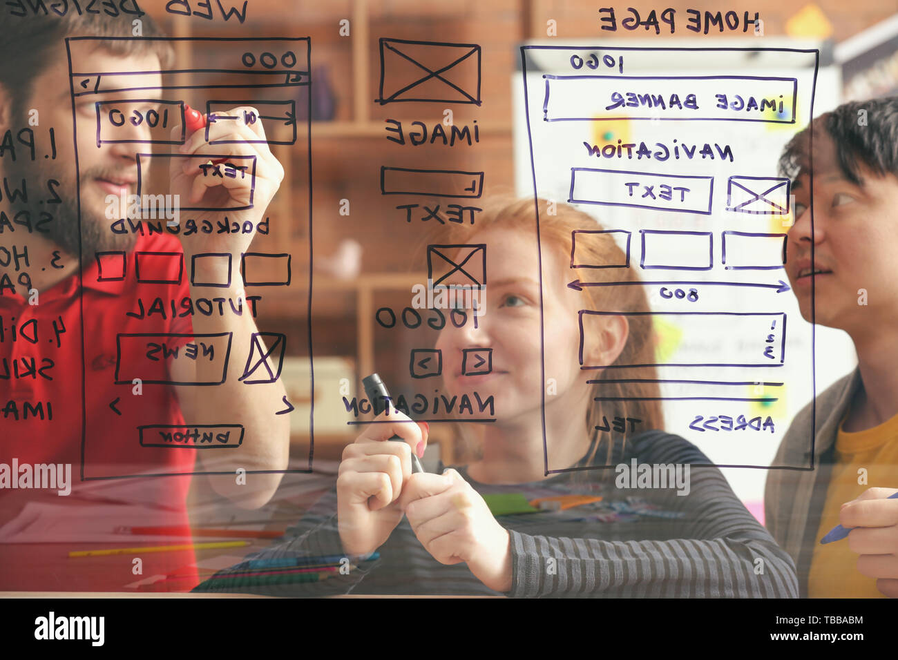 IT designers discussing project, view through transparent board Stock Photo