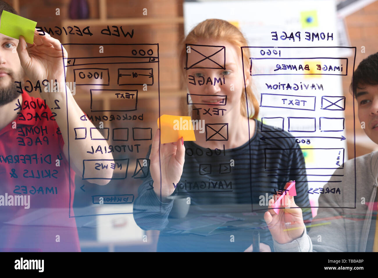 IT designers discussing project, view through transparent board Stock Photo