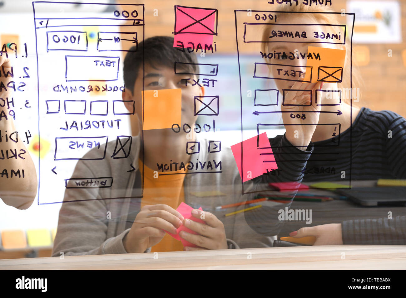 IT designers discussing project, view through transparent board Stock Photo