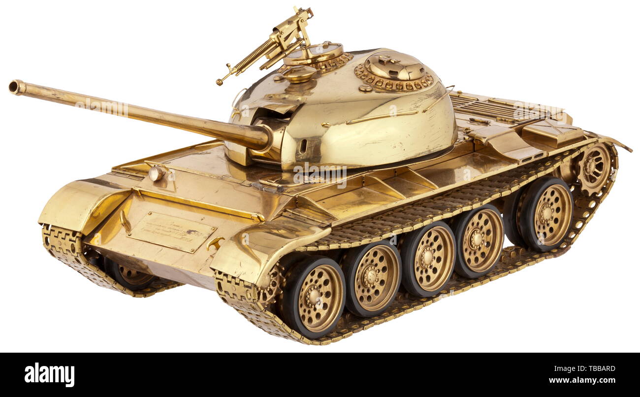 A large T 54/55 tank model as a jubilee gift of the Soviet Forces in Germany, from the year 1958, Brass, shining like gold, polished and varnished. Rotatable turret with vertically movable cannon and flak machine gun, movable tracks (rubber coating), movable rear hoods and track covers. Plaque on chassis with engraved Cyrillic dedication (tr.) 'For the soldats of the National People's Army (NVA) of the GDR from the Group of Soviet Forces in Germany (GSSD) to the two-year anniversary of the NVA'. Rubbed in places, few little screws on hoods missing (replaceable). Dimensions , Editorial-Use-Only Stock Photo