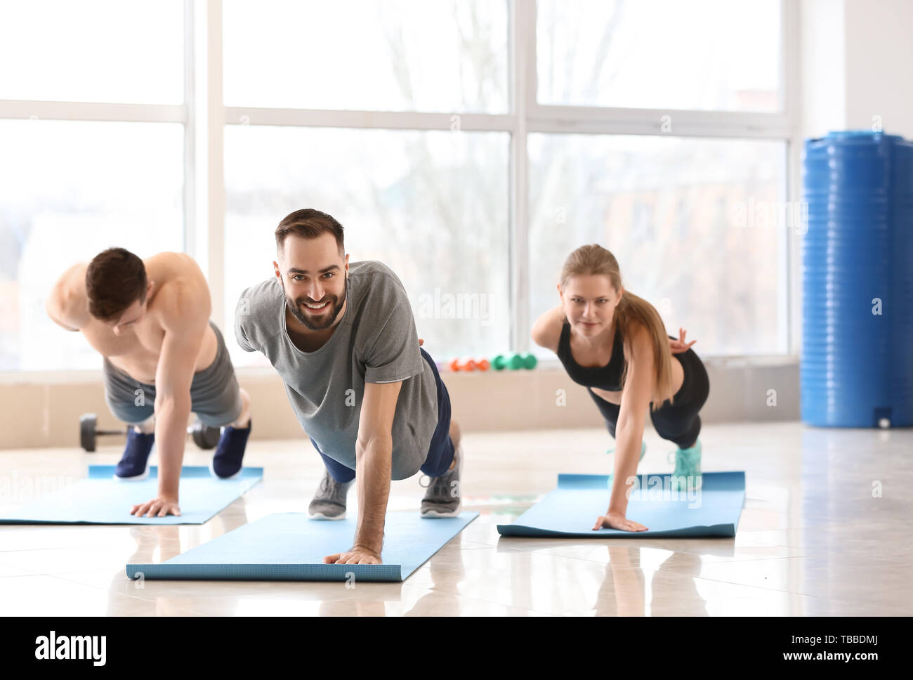 Sporty young people training in gym Stock Photo - Alamy