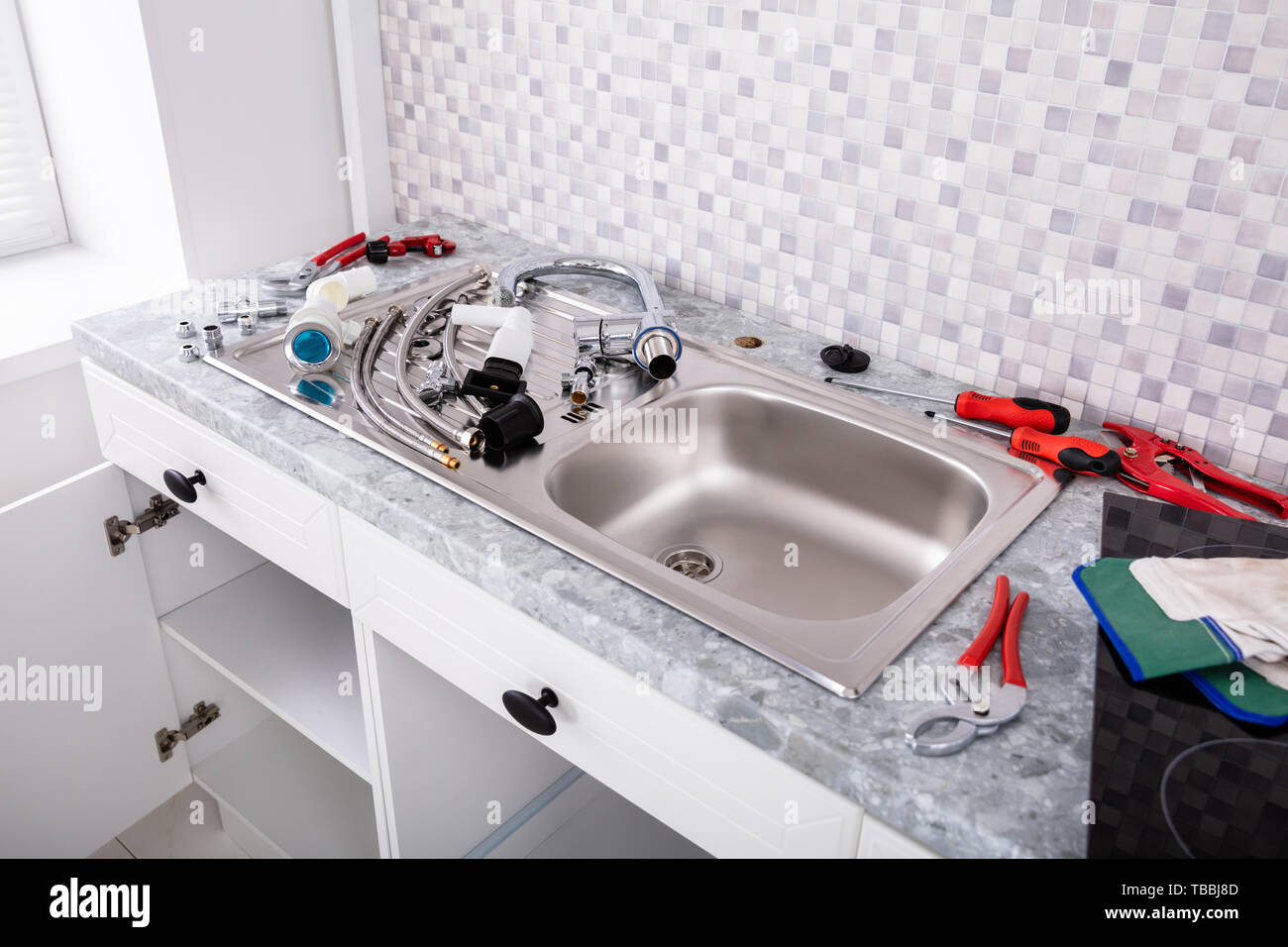 Installation Of Stainless Steel Sink In The Kitchen Stock Photo