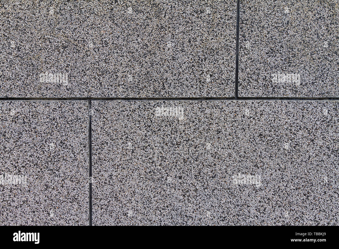 The crushed stone surface of the wall, separated by squares. Close up. Grey background. Stock Photo