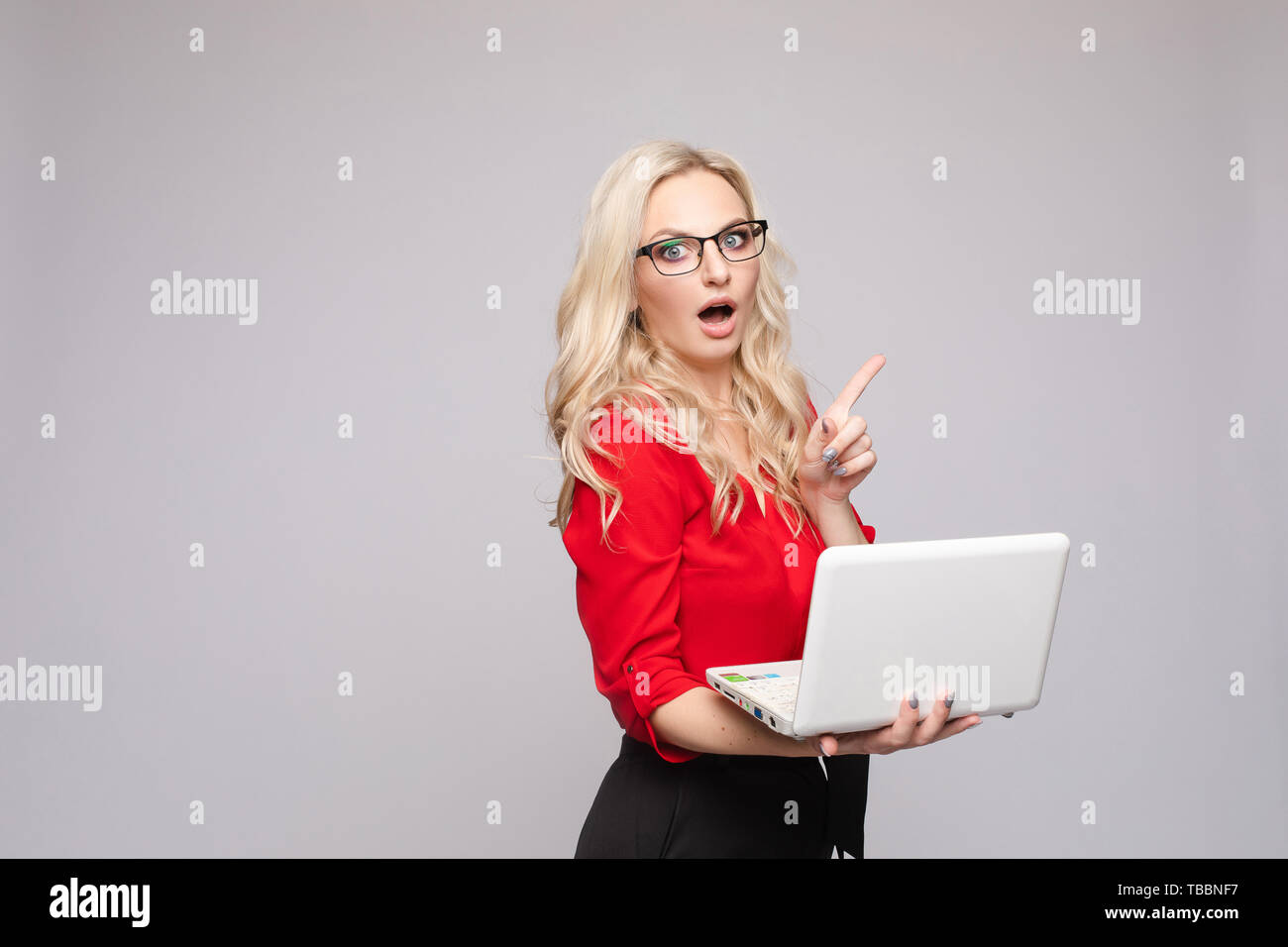 Shocked woman with open mouth keeping computer Stock Photo