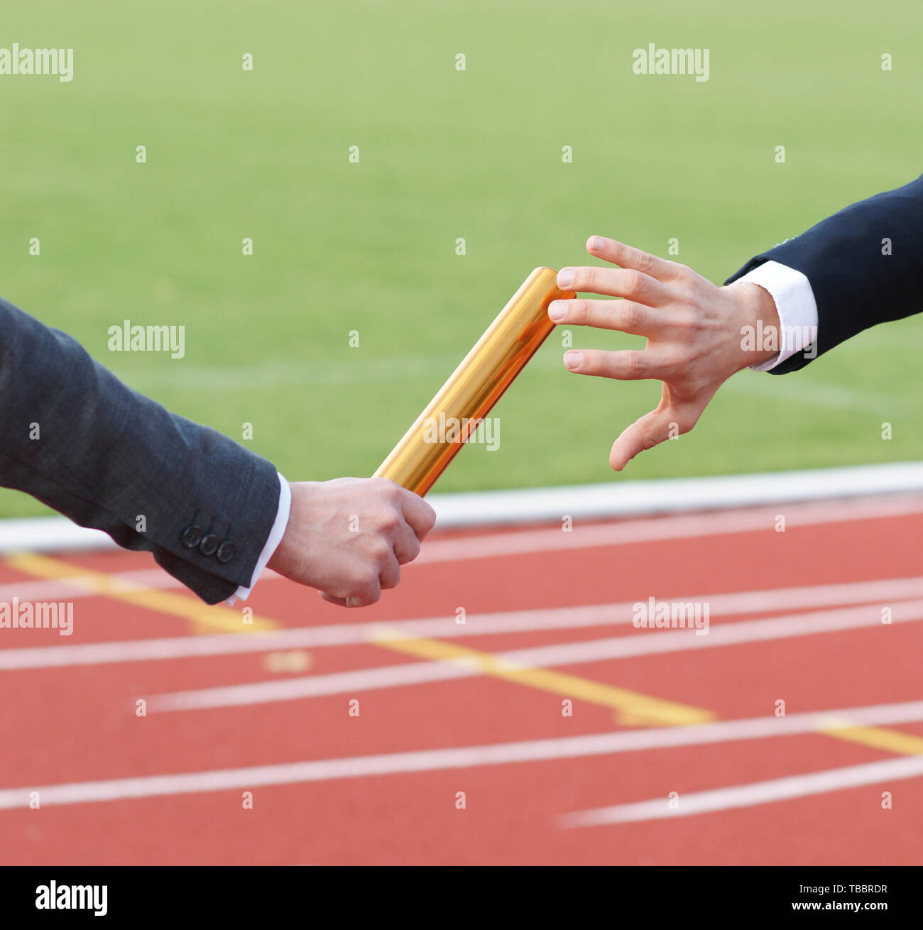 Businessman passing baton in relay race outside in stadium concept