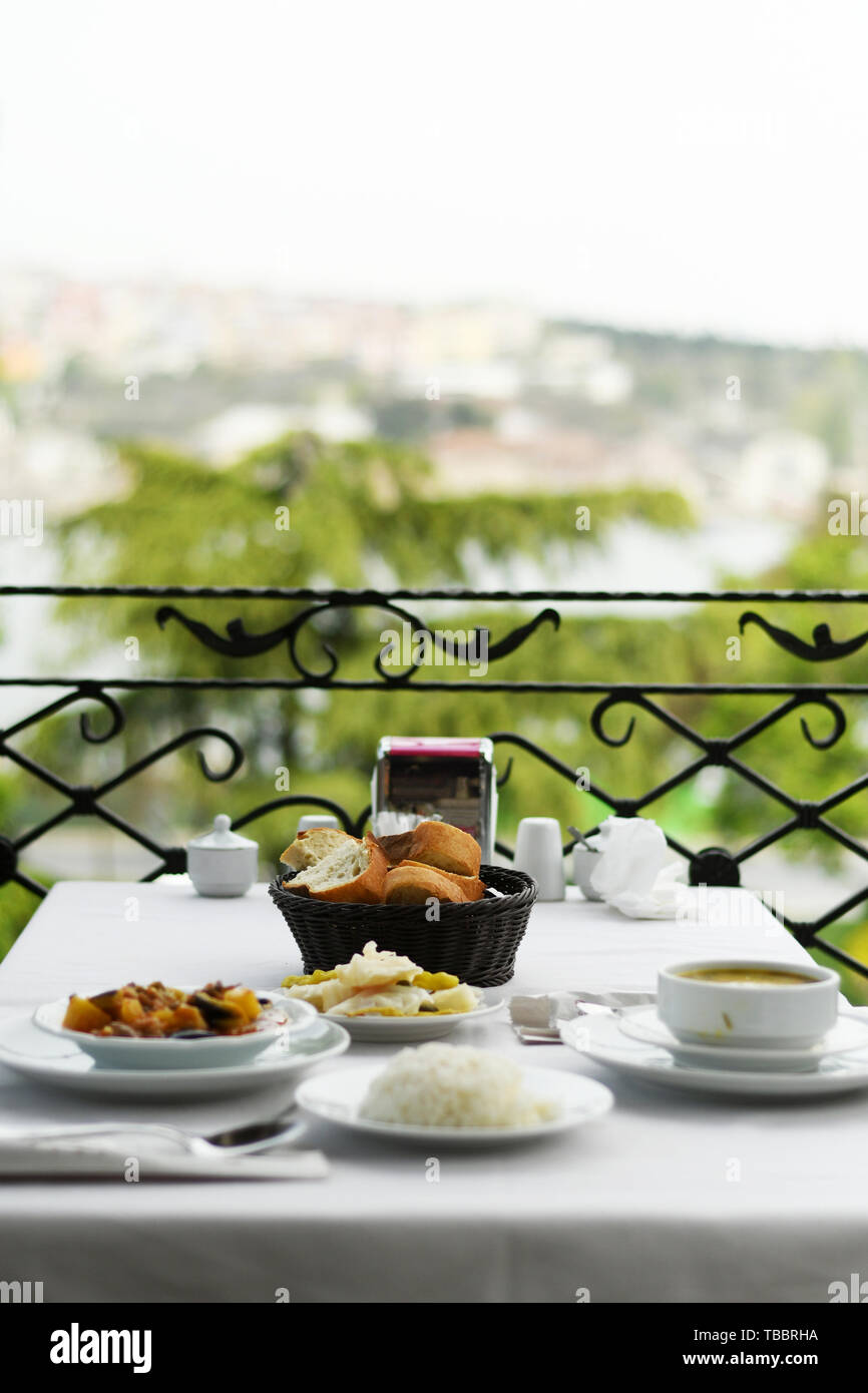 Dinner outside, food in plates on a balcony table Stock Photo