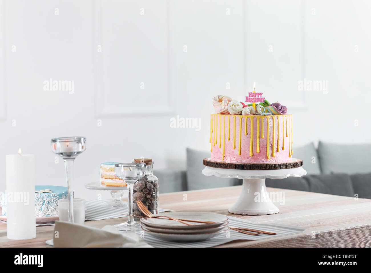 Tasty Cake With Burning Candle On Wooden Table In Room Stock