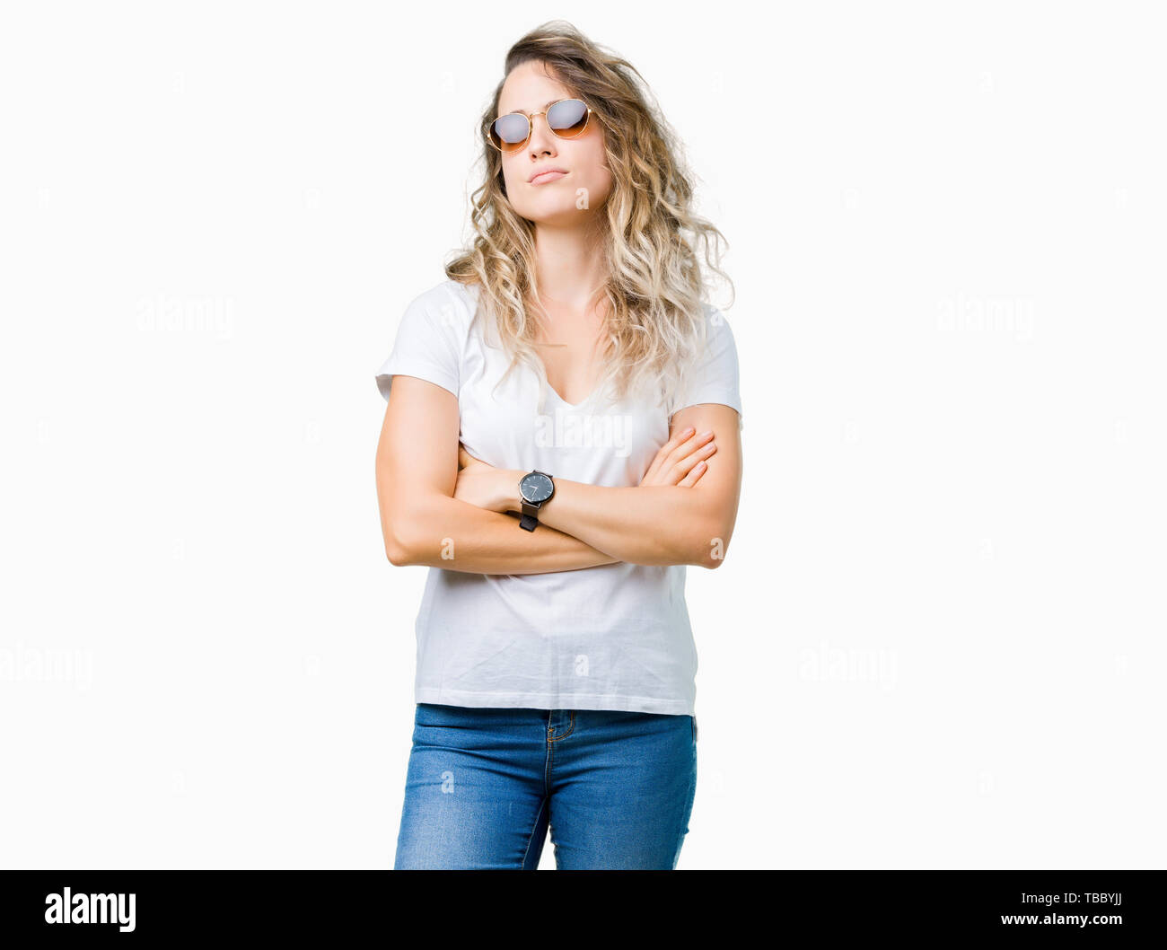 Beautiful young blonde woman wearing sunglasses over isolated background skeptic and nervous, disapproving expression on face with crossed arms. Negat Stock Photo