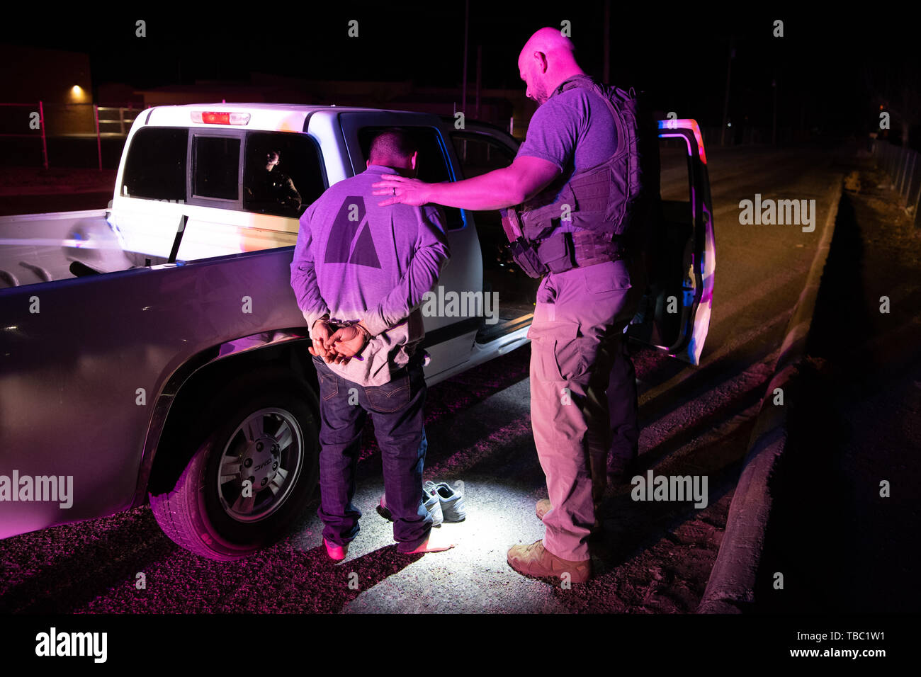 U.S. Marshals, federal, state and local law enforcement officers handcuff and arrest a fugitive March 7, 2019 in Las Cruces, New Mexico. The massive operation called Triple Beam resulted in the arrest of 154 fugitives from throughout Dona Ana County. Stock Photo