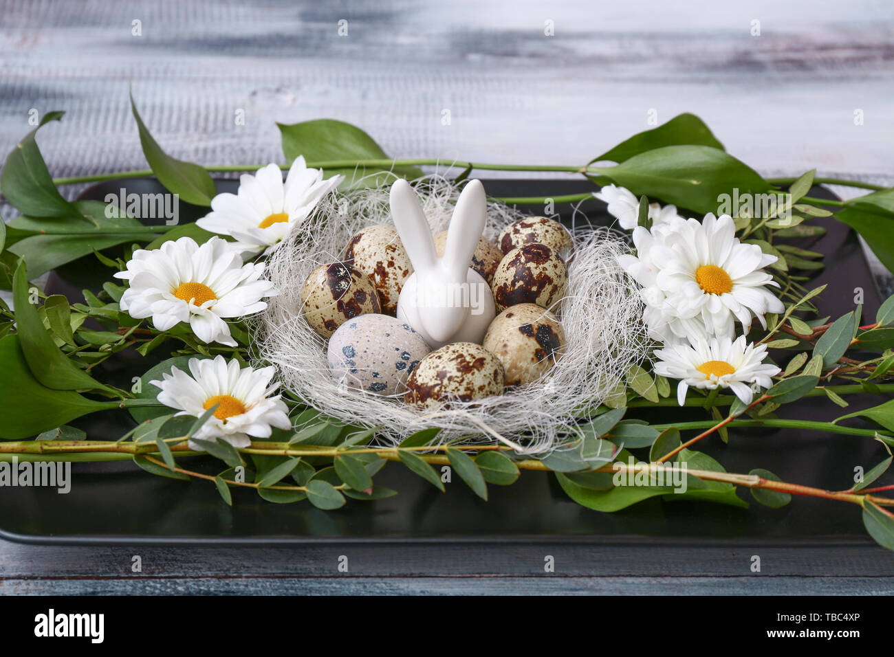Plate with Easter decor on wooden table Stock Photo