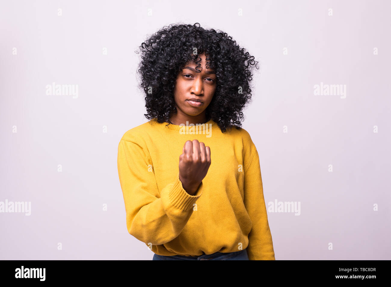 portrait of a happy young african curly woman showing fist pump ...
