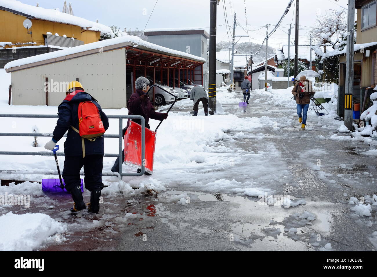 People clearing snow out of the street in Kanazawa city Stock Photo