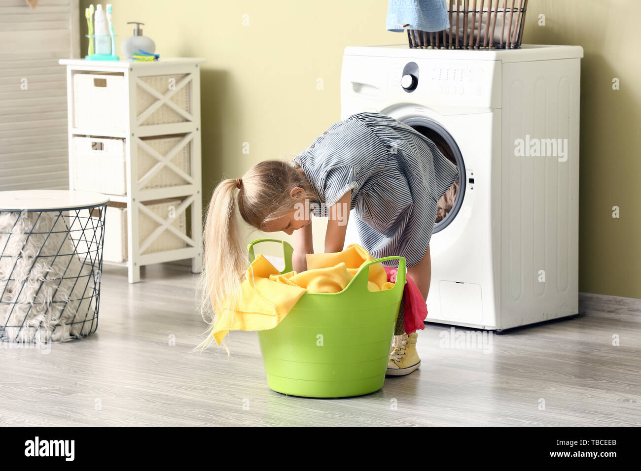 Little girl doing laundry at home Stock Photo Alamy