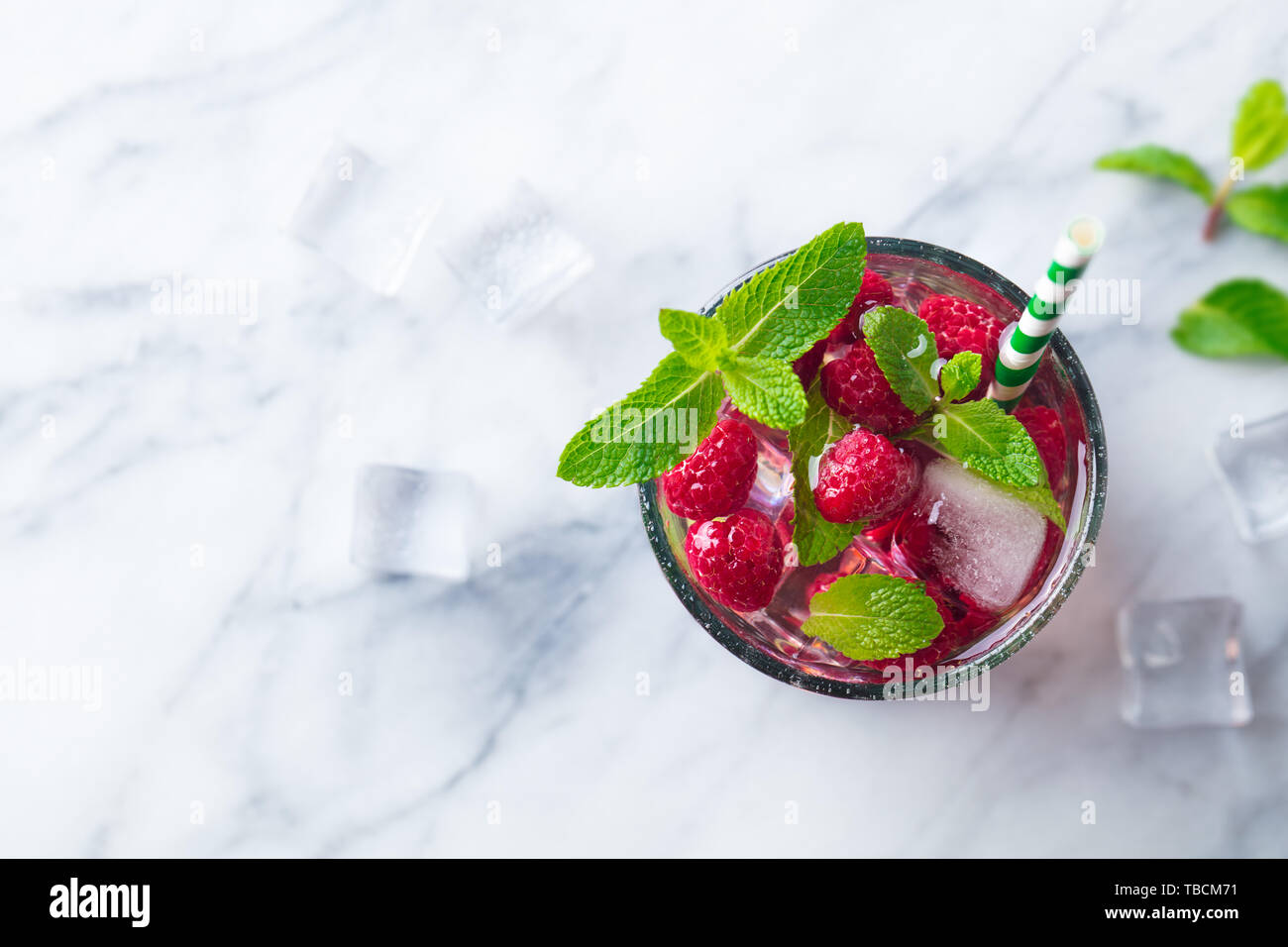 Raspberry cocktail, fizz, lemonade, ice tea with fresh mint on marble background. Top view. Copy space. Stock Photo
