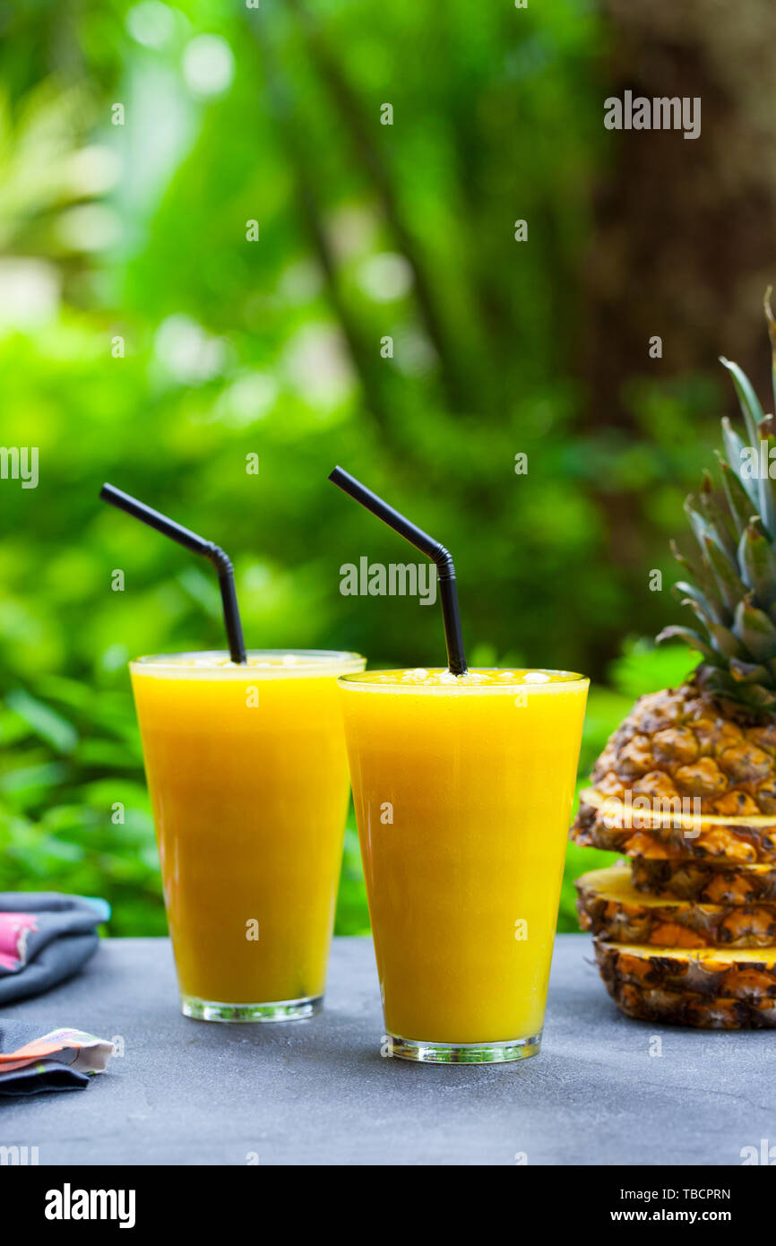 Pineapple with tropical fruit juice, smoothie on outdoor background. Copy space. Stock Photo