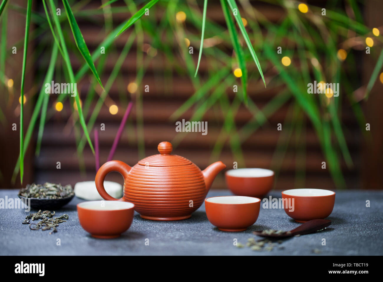 Green tea in tea pot and chawan bowls, cups. Outdoor background with