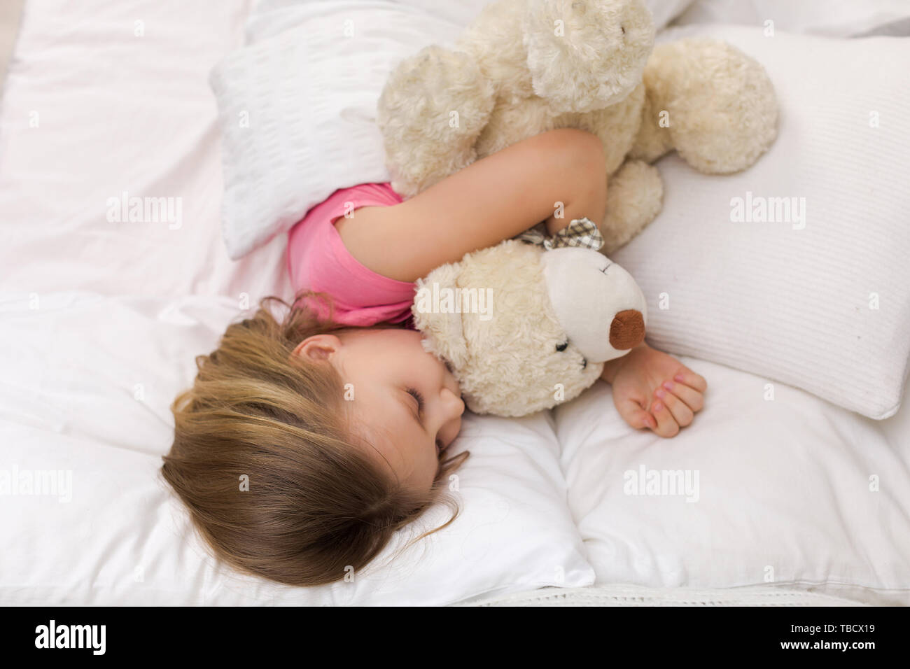 Cute little child girl sleeping with teddy bear in her bed Stock Photo ...