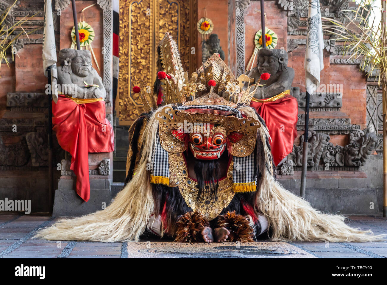 Banjar Gelulung, Bali, Indonesia - February 26, 2019: Mas Village. Play on stage setting. Dragon rises from the floor. Colorful mask with yellow, red, Stock Photo