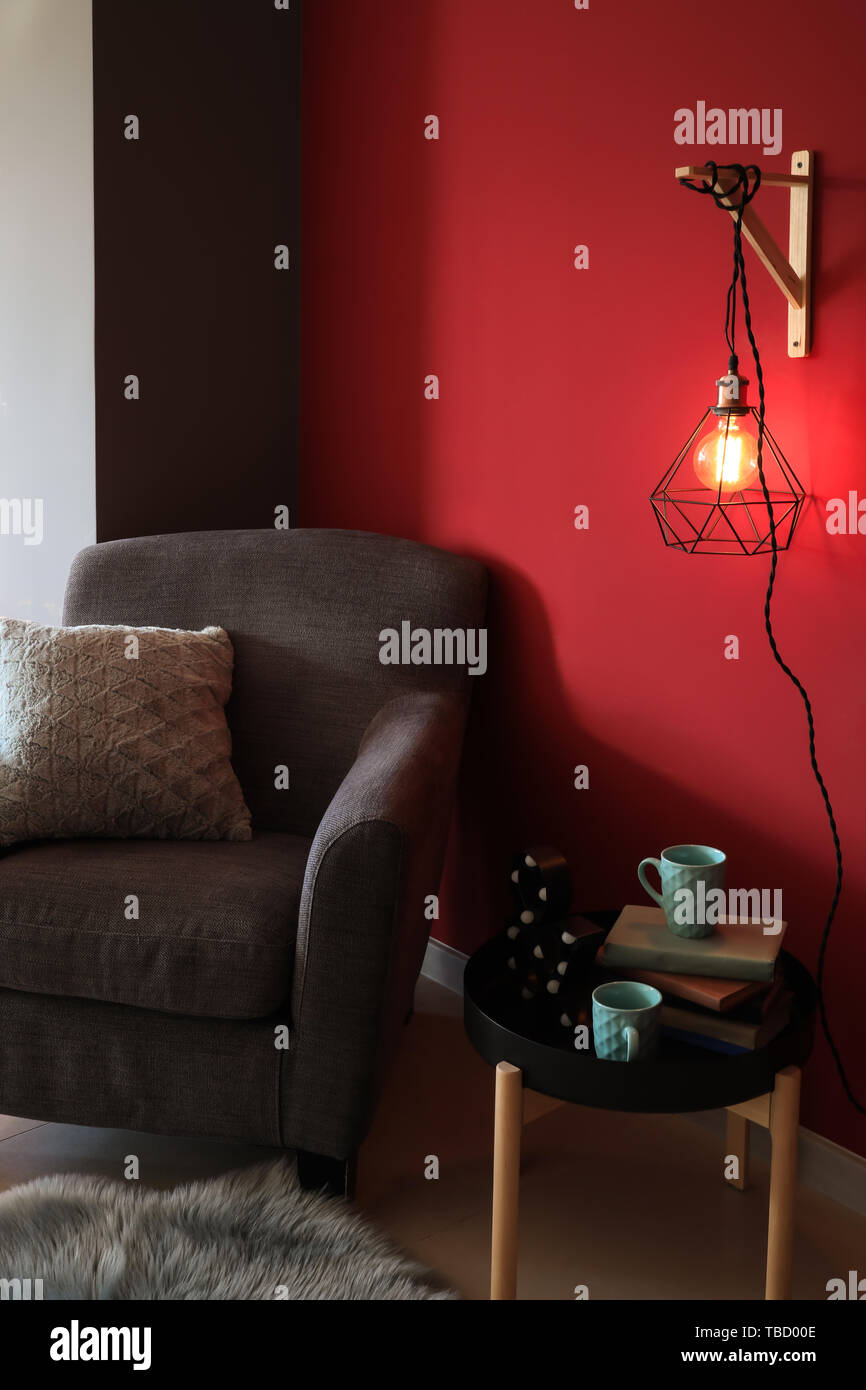 Stylish interior of room with soft armchair, table and new lamp Stock ...
