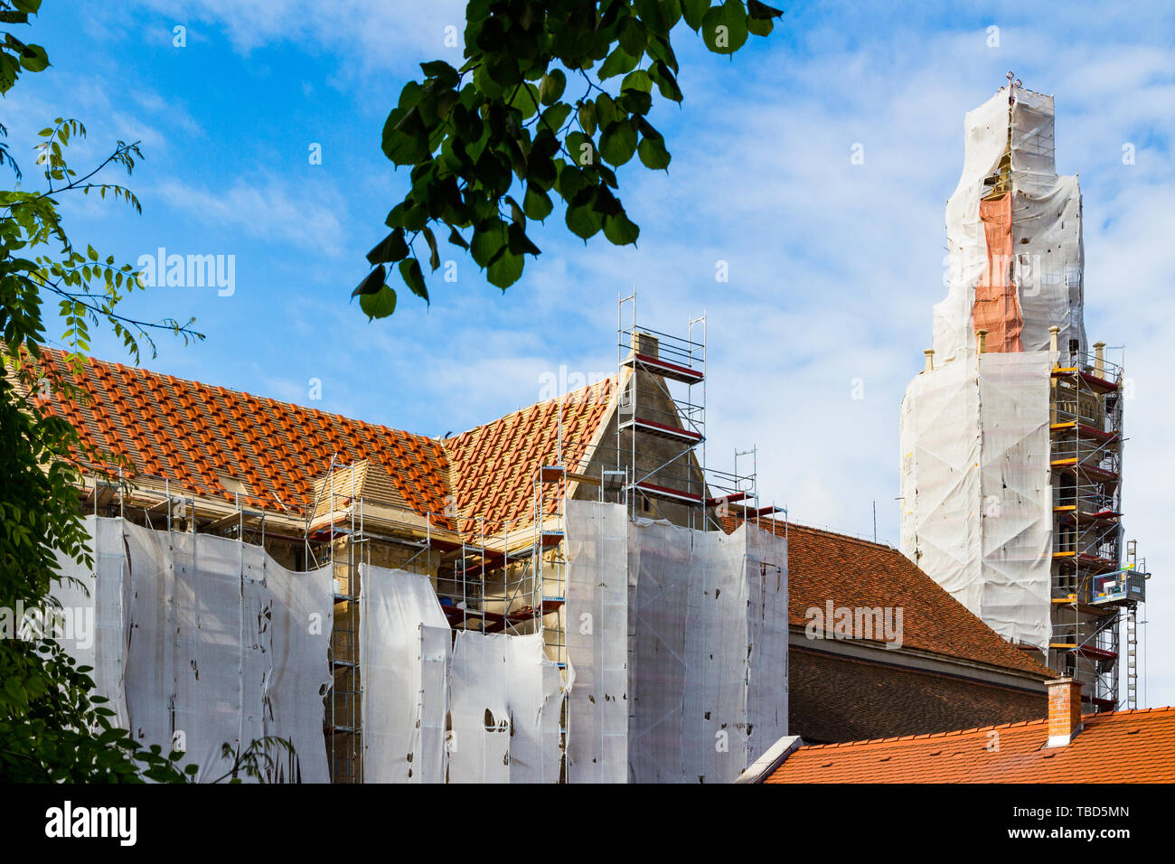 Medieval Saint Michael church renovation with scaffolding and construction elevator in Sopron, Hungary Stock Photo