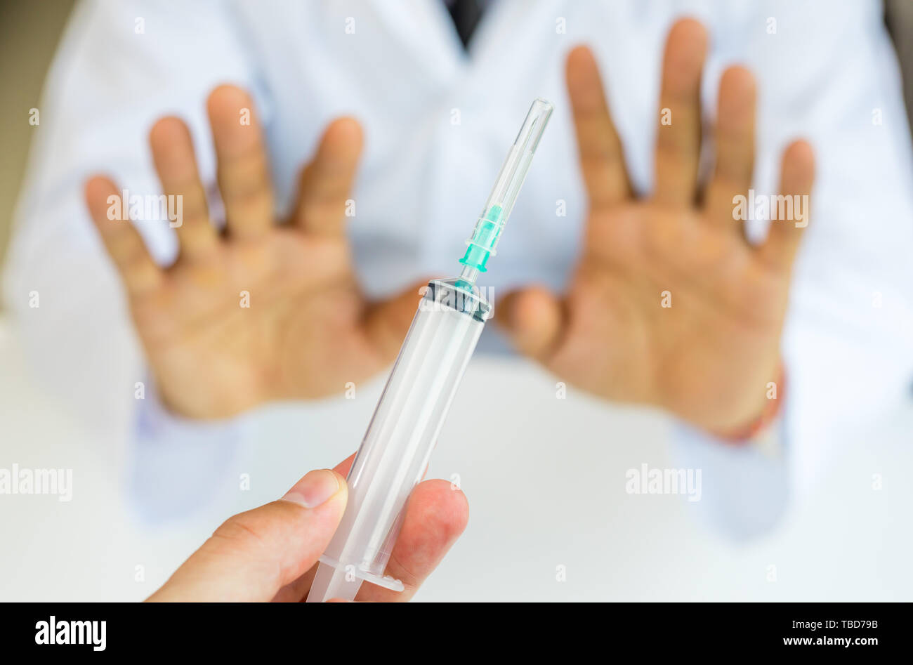 Man gesturing with hand and refusing injection or vaccination Stock Photo