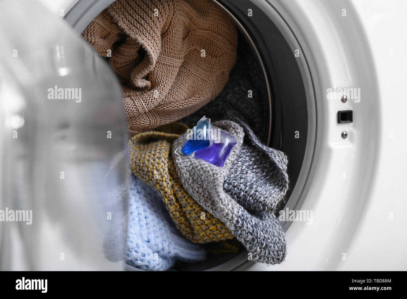 Washing machine with laundry and detergent pod, closeup Stock Photo Alamy