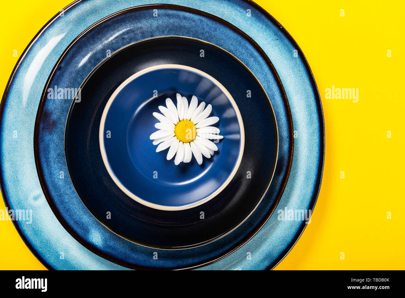 Empty Blue Plates on Bright Yellow Background, Top View, Copy Space Stock Photo