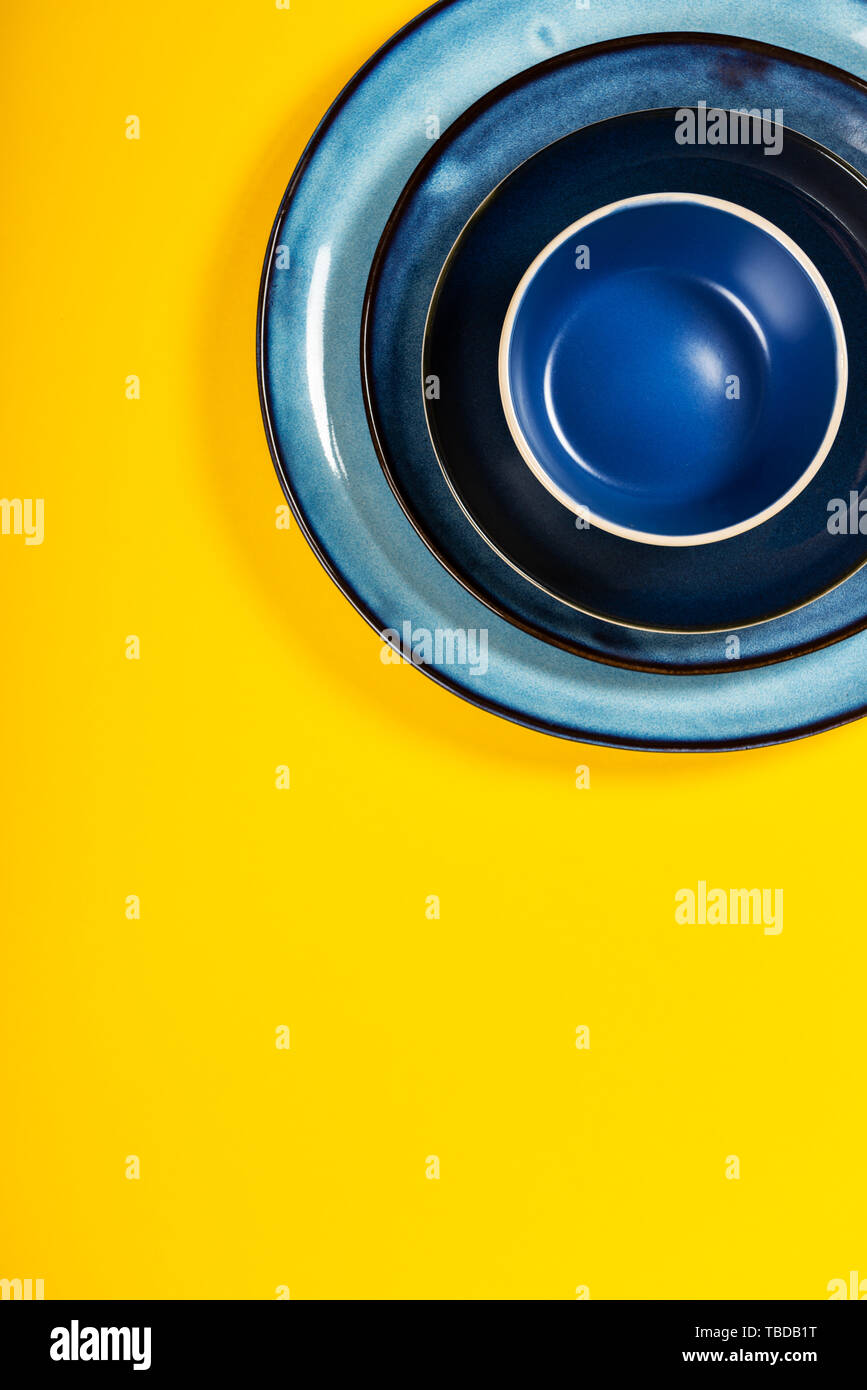 Empty Blue Plates on Bright Yellow Background, Top View, Copy Space Stock Photo