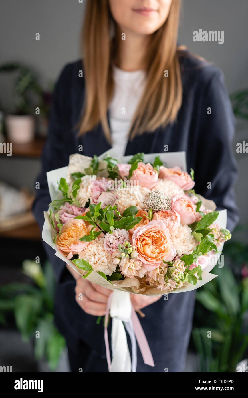 Small Beautiful bouquet of mixed flowers in woman hand. Floral shop