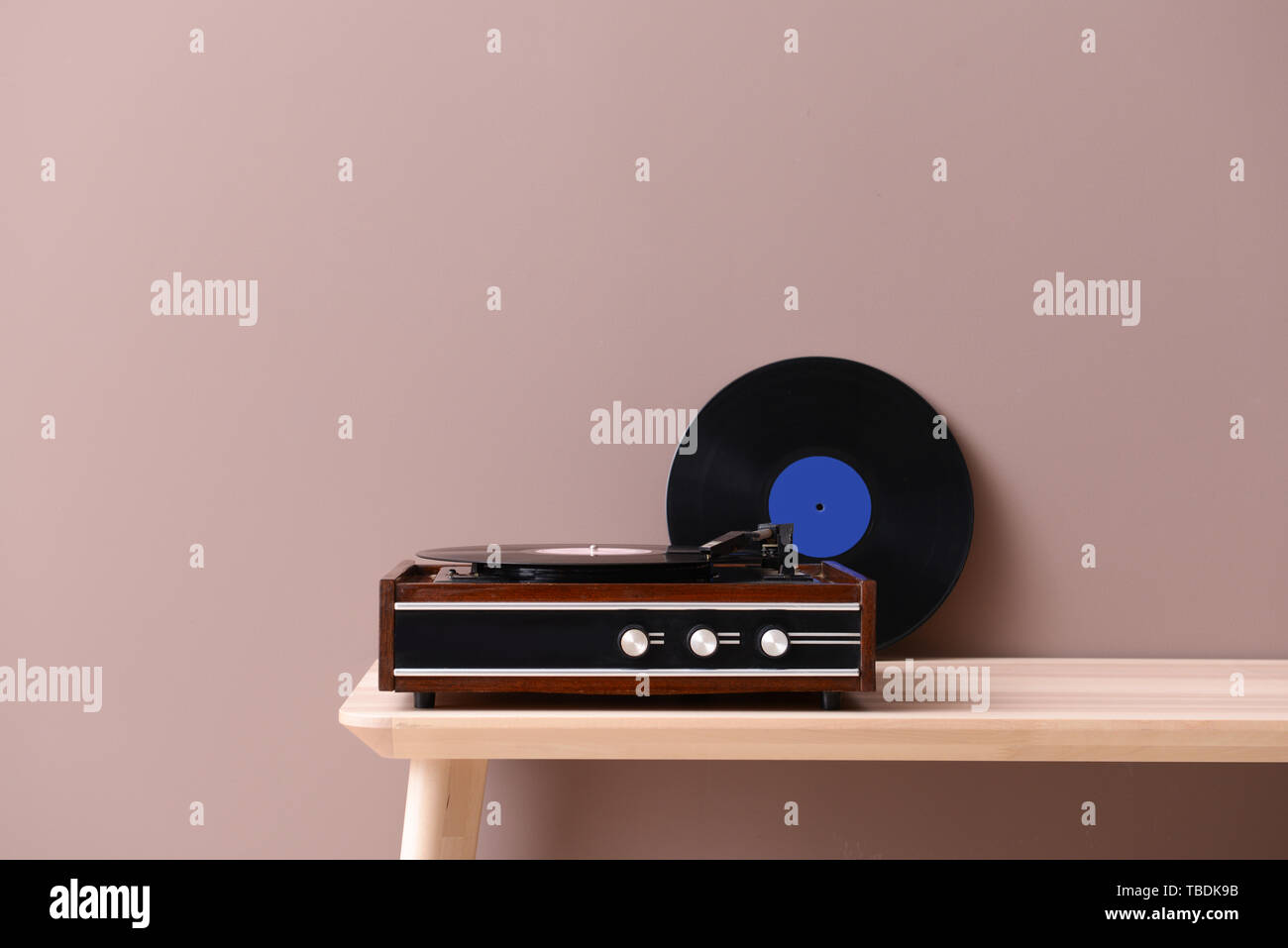 Record player with vinyl disc on table near color wall Stock Photo - Alamy