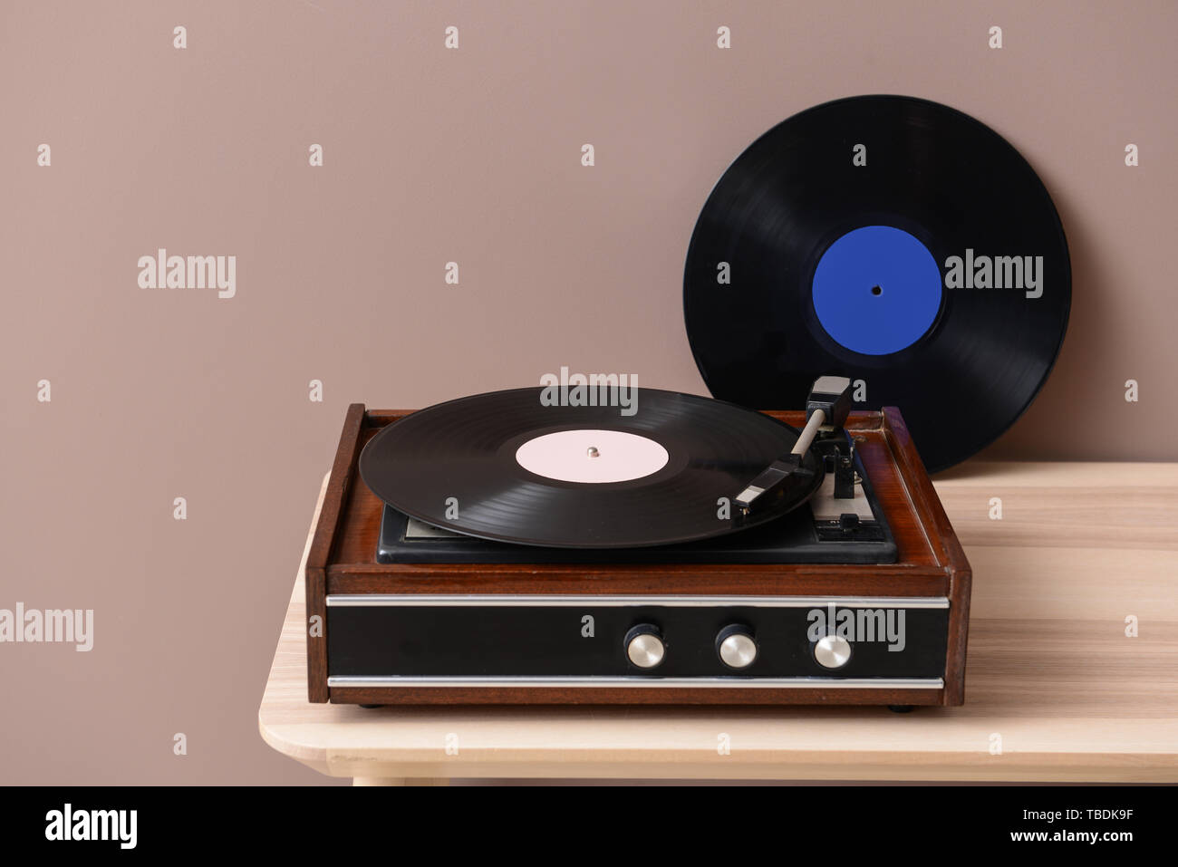 Record player with vinyl disc on table near color wall Stock Photo - Alamy
