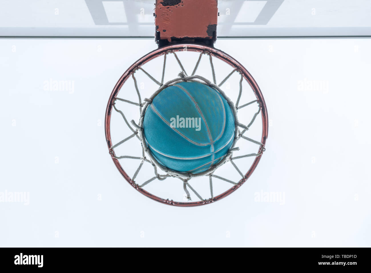 A basketball goes through the net on a neighborhood playground Stock Photo