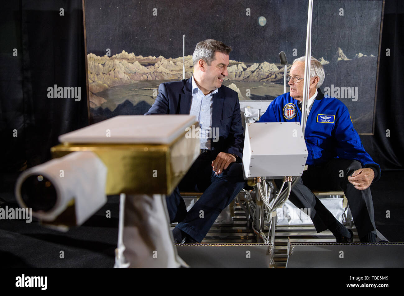 Munich, Germany. 01st June, 2019. Markus Söder (CSU, l), Prime Minister of Bavaria, and Charlie Duke, former US astronaut, are sitting in a replica of a moon car (Lunar Roving Vehicle) in the German Museum as part of an event marking the 50th anniversary of the moon landing. In the background you can see the oil painting 'Ideal Moon Landscape' from 1919 by Wilhelm Kranz. Duke is one of four people who were on the moon and can still talk about it. Credit: Matthias Balk/dpa/Alamy Live News Stock Photo