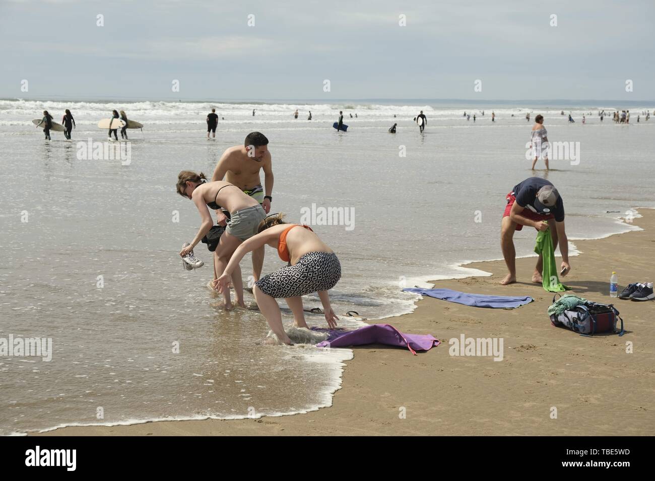 Gower, Swansea, Wales, UK. 1st June 2019. Weather: The racing tide caught these sunbathers by surprise. Beachgoers enjoyed a warm day with some cloud and spells of hazy sunshine at Llangennith beach on the Gower peninsula, near Swansea, South Wales. Cloud is forecast to build overnight and rain is forecast. Credit: Gareth Llewelyn/Alamy Live News Stock Photo