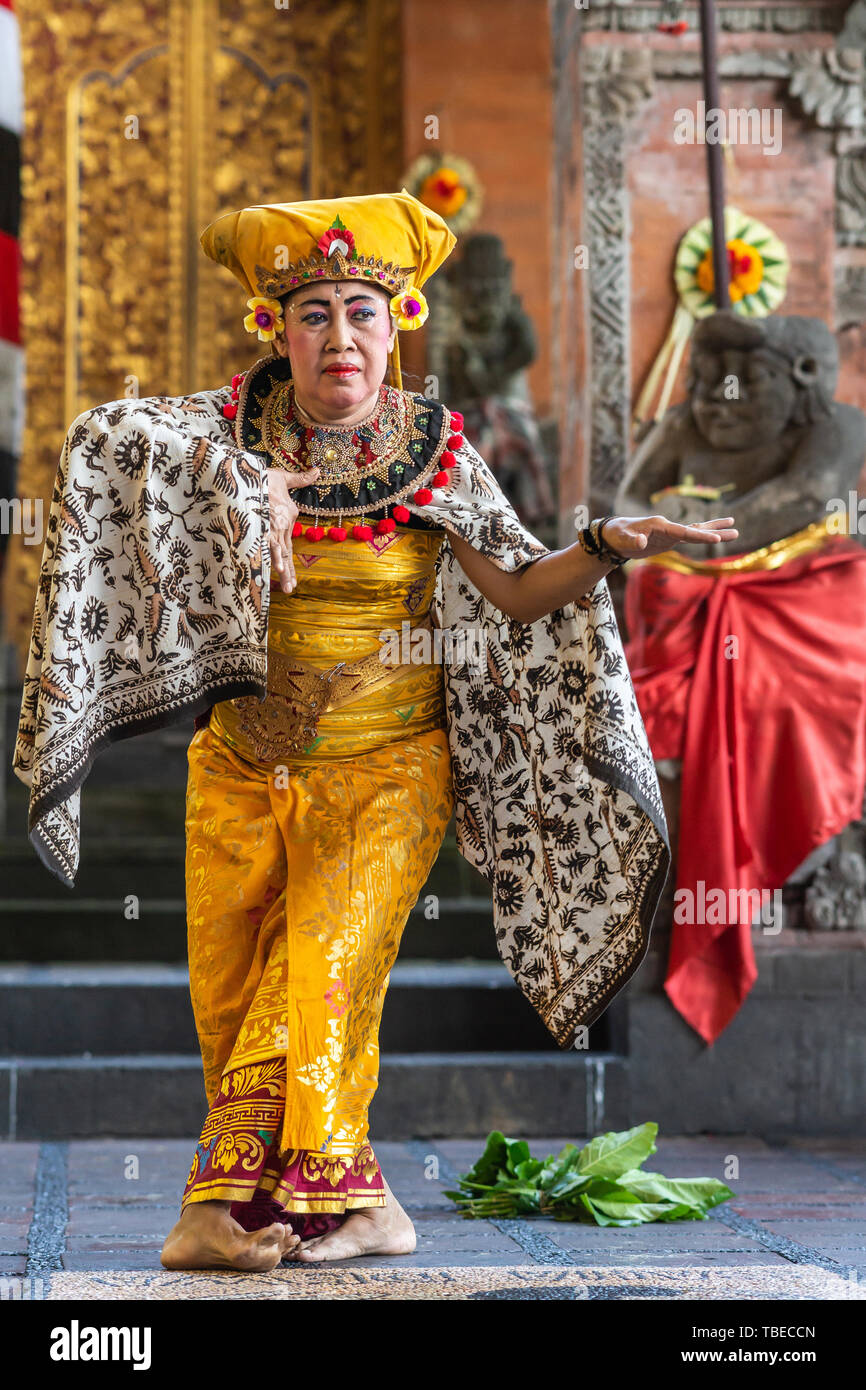 Banjar Gelulung, Bali, Indonesia - February 26, 2019: Mas Village. Play on stage setting. Closeup of dancing Queen in traditional garb with golds, bla Stock Photo