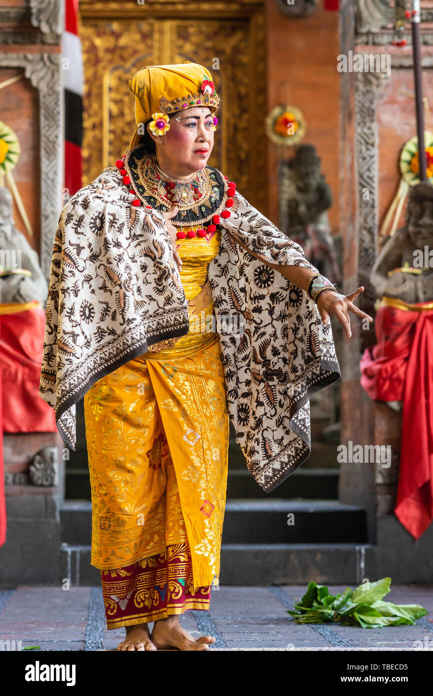 Banjar Gelulung, Bali, Indonesia - February 26, 2019: Mas Village. Play on stage setting. Closeup of dancing Queen in traditional garb with golds, bla Stock Photo