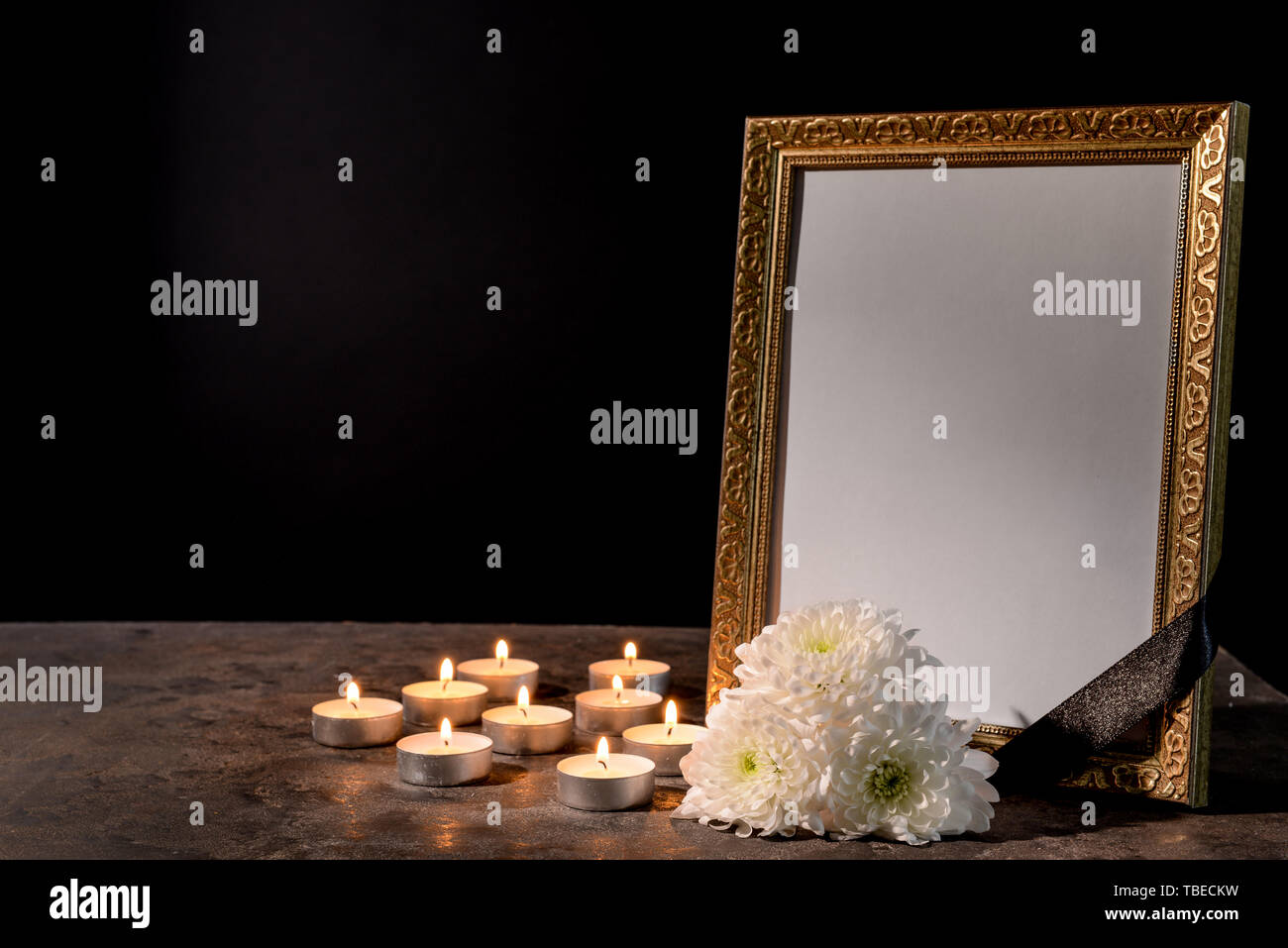 Blank funeral frame, candles and flowers on table against black background  Stock Photo - Alamy