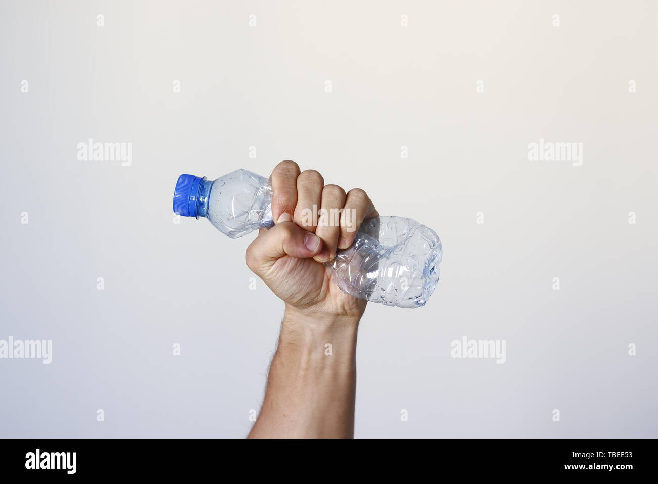 Hand squeezing Plastic Bottle representing movement against pollution