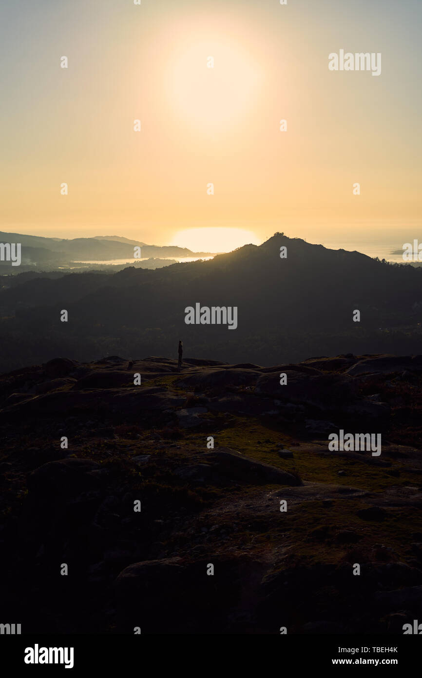 Silhouette of a person contemplating an enormous landscape from Mount Galiñeiro in Vigo, Spain Stock Photo