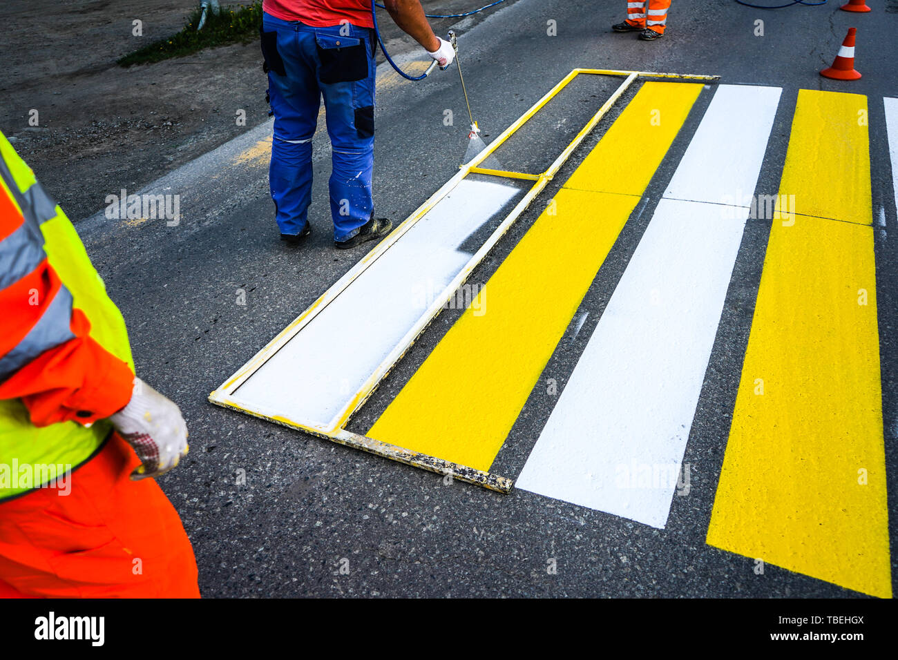 Road marking. Painting road lines. Workers draw white and yellow