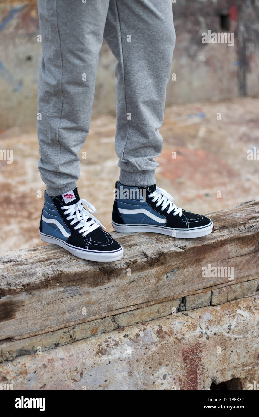 Cape Town, South Africa. 01 June 2019. A pair of black and blue hi top Vans  sneakers on feet of a man standing on a grungy wooden ledge Stock Photo -  Alamy