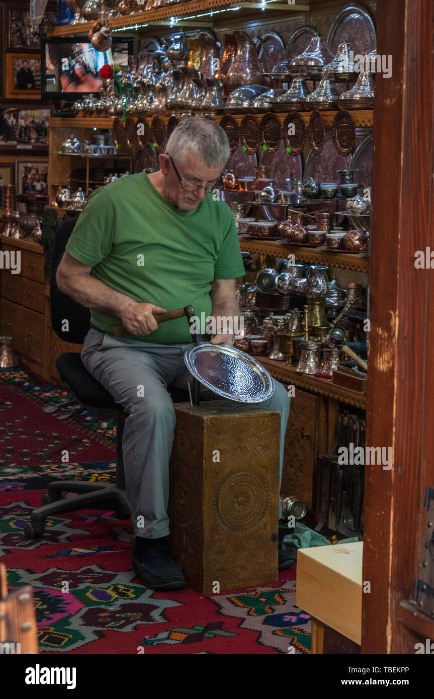 Sarajevo: a coppersmith at work inside his workshop in the Coppersmith Street in the heart of Bascarsija, old bazaar and historical center of the city Stock Photo