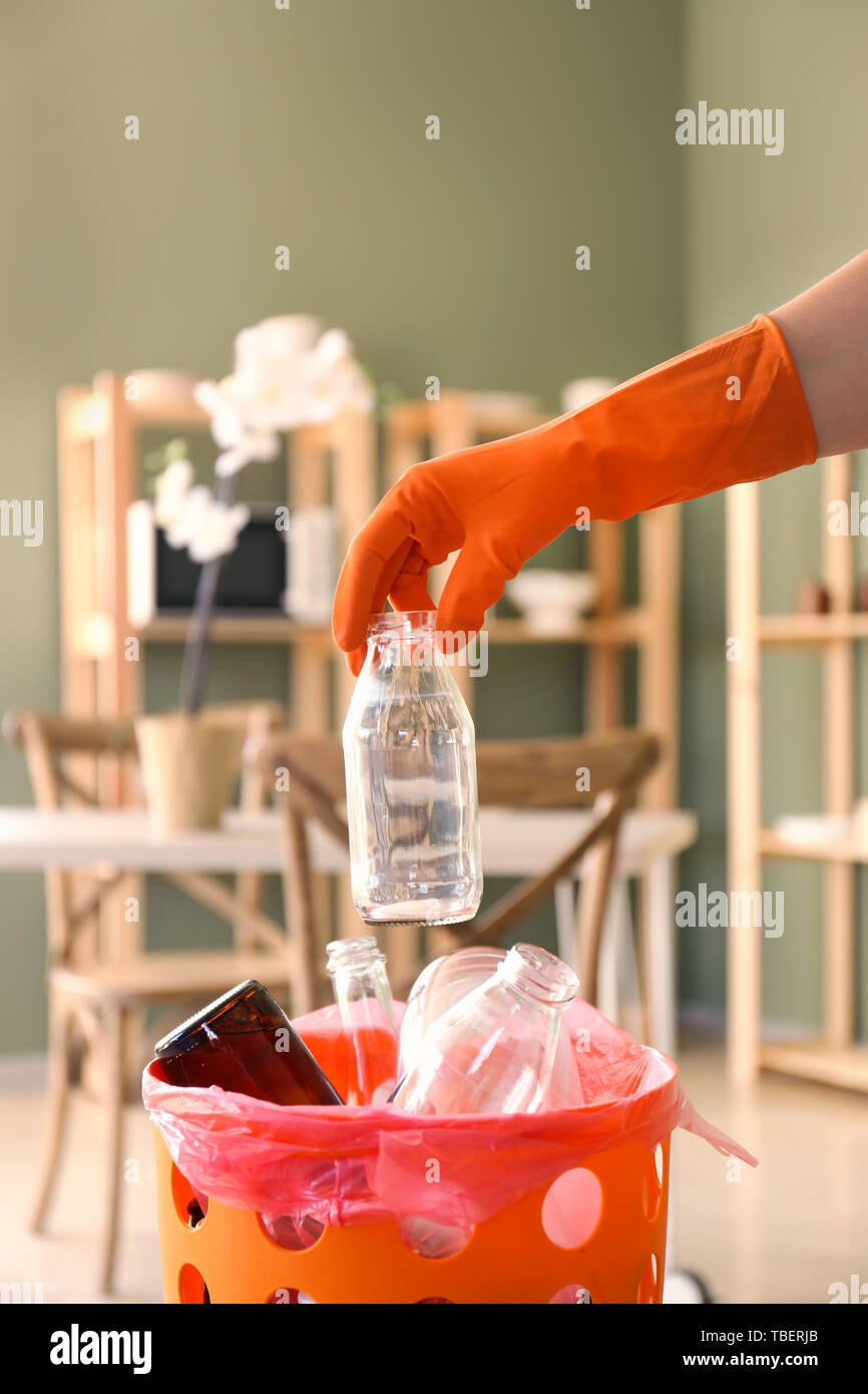 Woman throwing glass bottles in trash bin Stock Photo Alamy