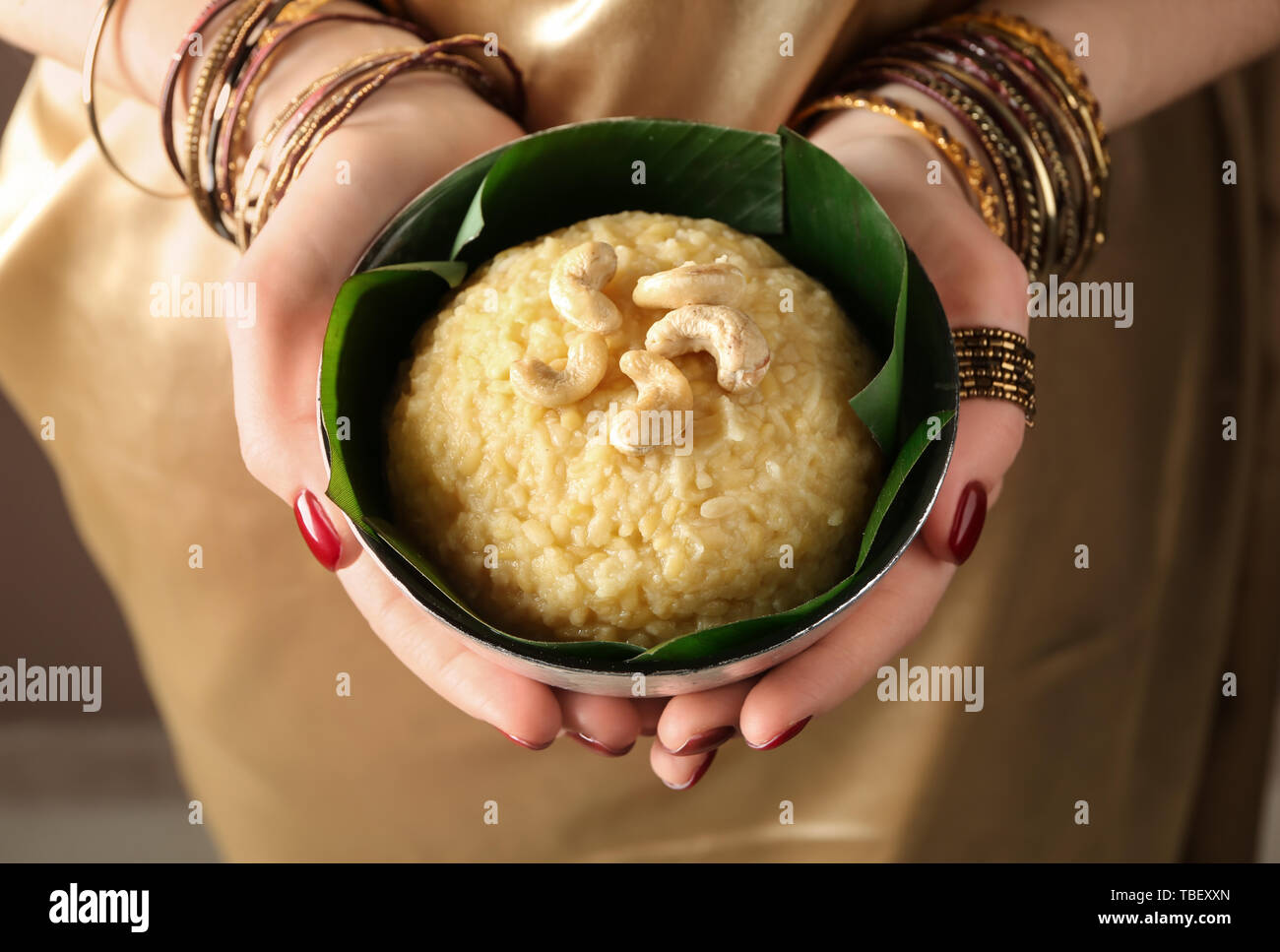 Woman holding bowl with traditional Indian food pongal, closeup Stock Photo